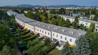 die Wohnhausanlage Tenschertstraße mit kleinen Gärten und Terrassen sowie Flachdächern mit Kiesbestreuung