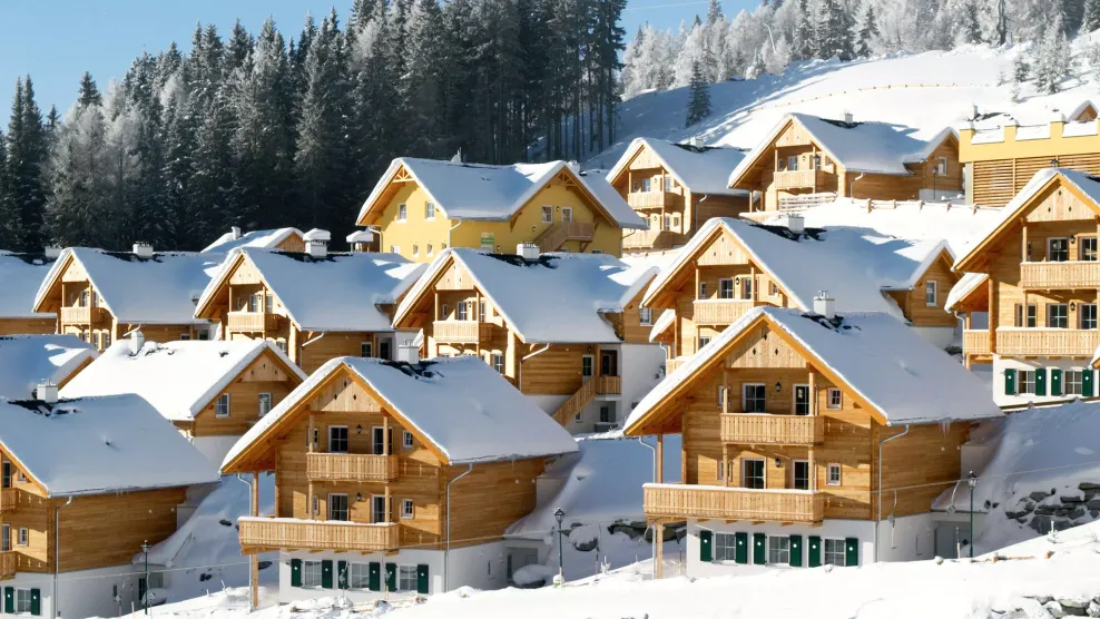 hölzerne Reihenhäuser mir Holzfassade und mehreren Balkonen in einer schönen weißen Winterlandschaft