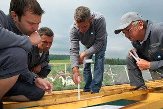 konzentriertes und aufmerksames Arbeiten von Dachdeckern während des Baues