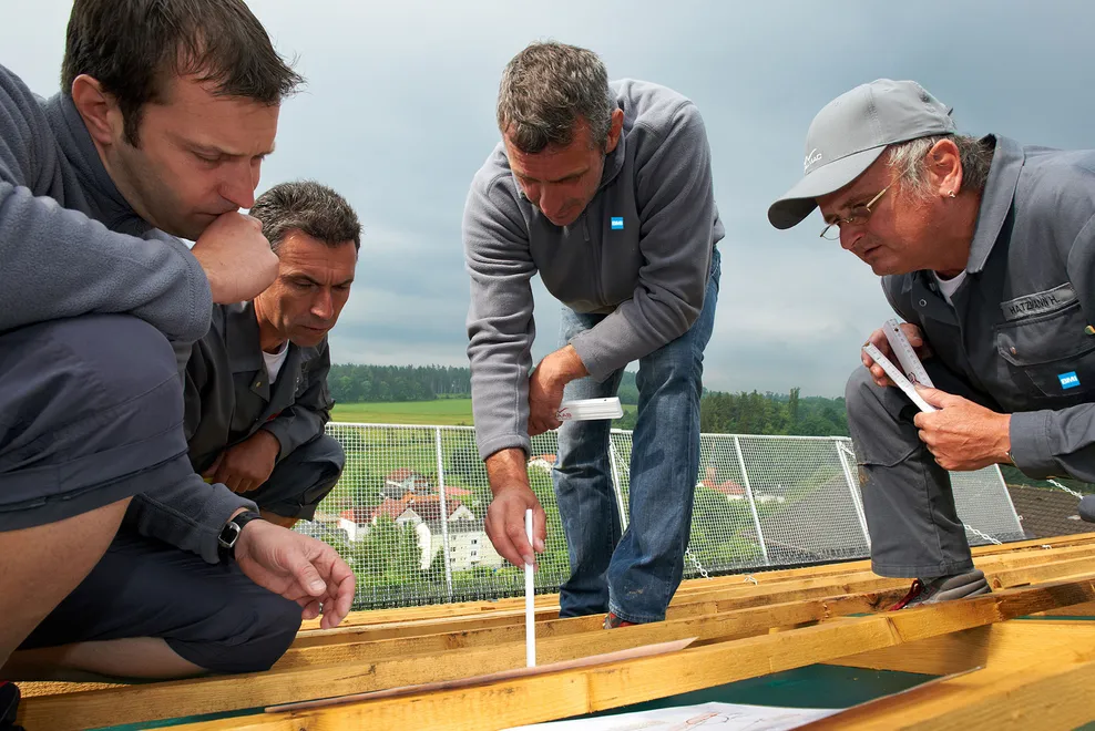 konzentriertes und aufmerksames Arbeiten von Dachdeckern während des Baues
