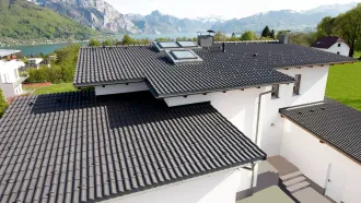 Haus mit 7 Grad Dachneigung und weißer Fassade sowie See inklusive Bergpanorama