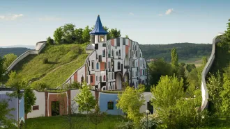 buntes Gebäude mit großer Gründachfläche inmitten einer ländlichen Landschaft
