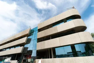 Präzision, Performance und Eleganz finden bei diesem Gebäude zusammen und verleihen diesen ein modernes Erscheinungsbild aufgrund der weitläufigen Glasfronten und Holzverkleidungen 