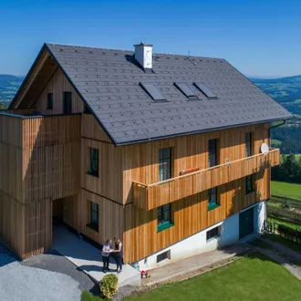 Haus mit verschiedenen Steildachzubehör und Holzfassade in ländlichen Umgebung
